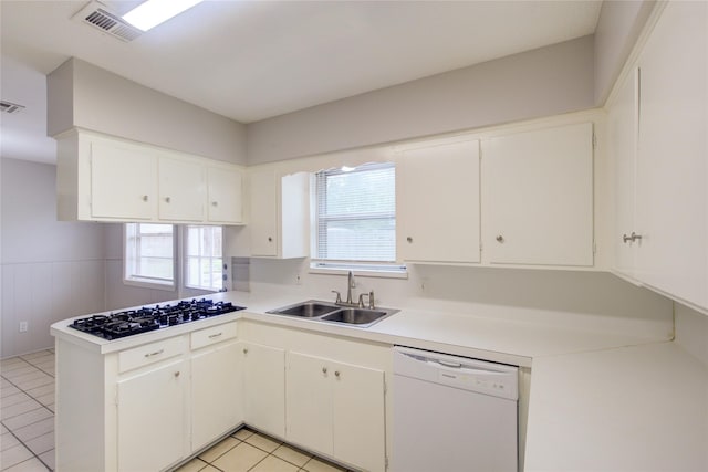 kitchen featuring light tile patterned flooring, white appliances, sink, white cabinetry, and kitchen peninsula