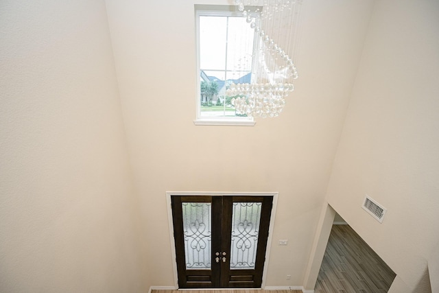 foyer entrance with french doors and a chandelier