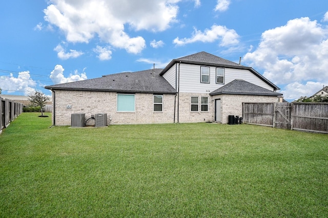 rear view of property featuring central AC and a lawn