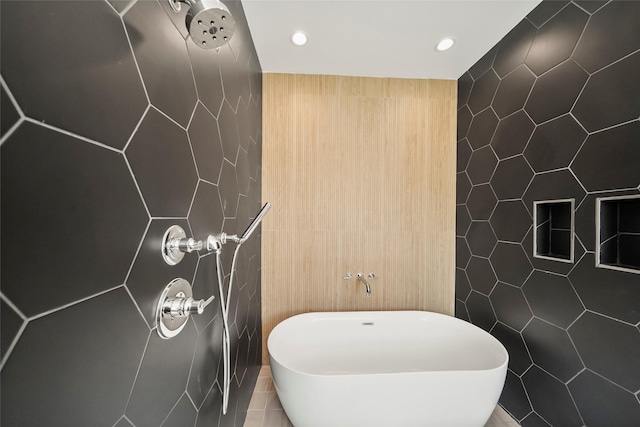 bathroom featuring recessed lighting, a freestanding bath, tile walls, and tiled shower