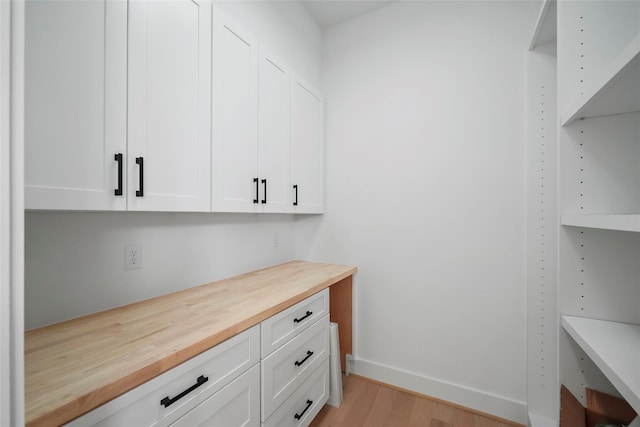 bar with white cabinetry, wooden counters, and light wood-type flooring