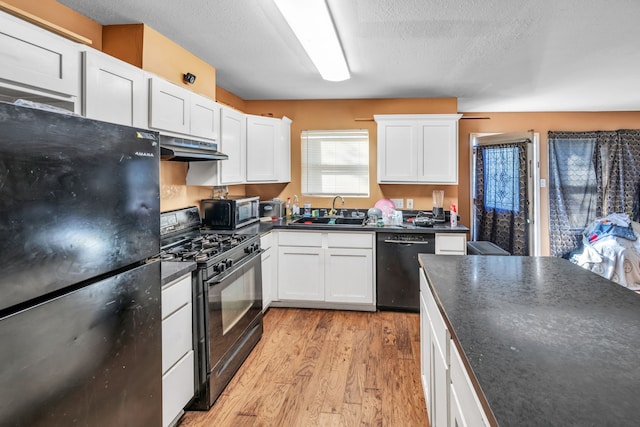 kitchen featuring white cabinetry, sink, black appliances, and light hardwood / wood-style floors