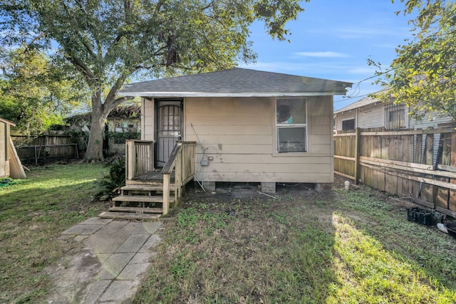 back of property with an outbuilding and a yard