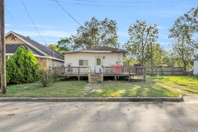 rear view of house featuring a lawn and a deck