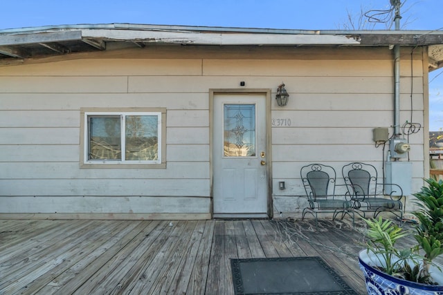 view of exterior entry featuring a wooden deck