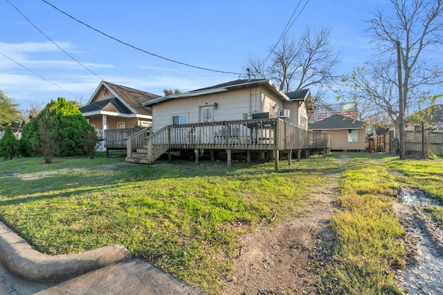 rear view of house featuring a lawn and a wooden deck