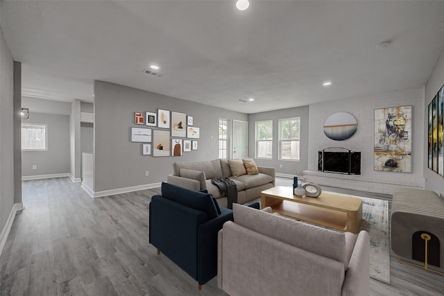 living room featuring light wood-type flooring and a brick fireplace