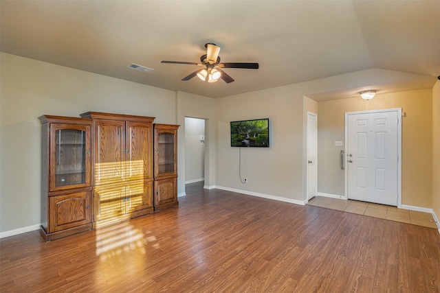 unfurnished living room featuring dark hardwood / wood-style floors, ceiling fan, and lofted ceiling