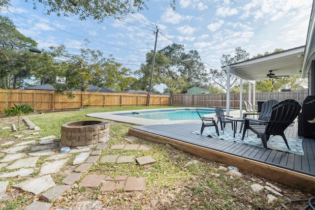 view of pool featuring a wooden deck and a fire pit