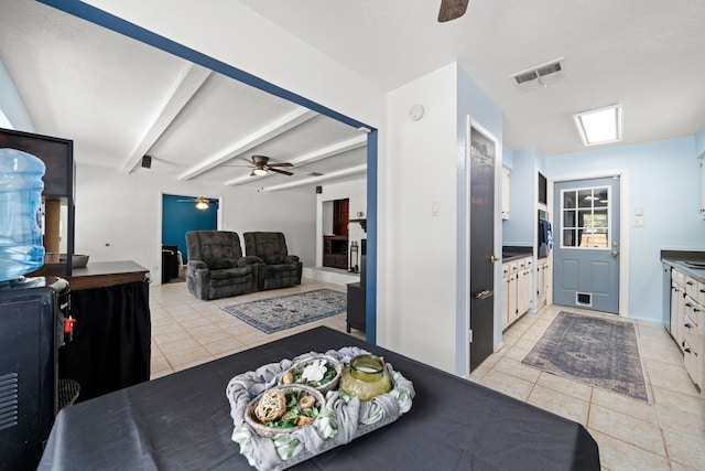 tiled dining area featuring beamed ceiling, a textured ceiling, and ceiling fan