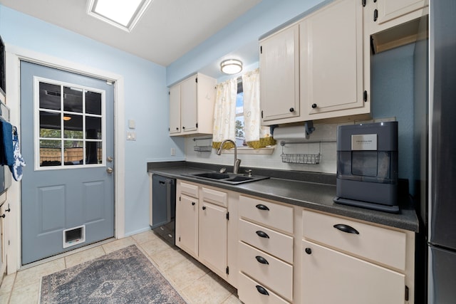 kitchen with backsplash, sink, light tile patterned floors, black dishwasher, and stainless steel refrigerator