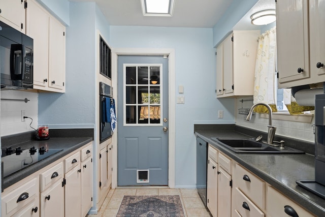 kitchen featuring light tile patterned floors, sink, a healthy amount of sunlight, and black appliances