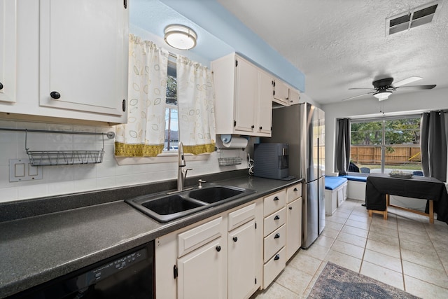 kitchen featuring sink, black dishwasher, light tile patterned flooring, backsplash, and white cabinets