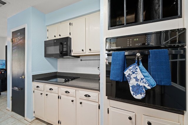 kitchen featuring light tile patterned flooring, backsplash, white cabinetry, and black appliances