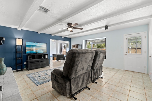 living room with beam ceiling, a textured ceiling, ceiling fan, and light tile patterned flooring