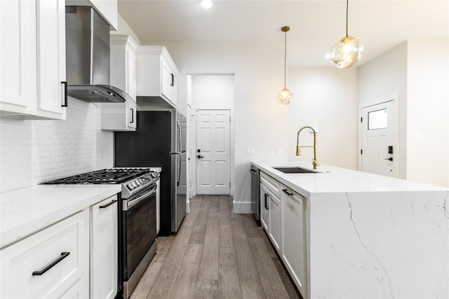 kitchen featuring sink, stainless steel appliances, white cabinetry, and wall chimney range hood