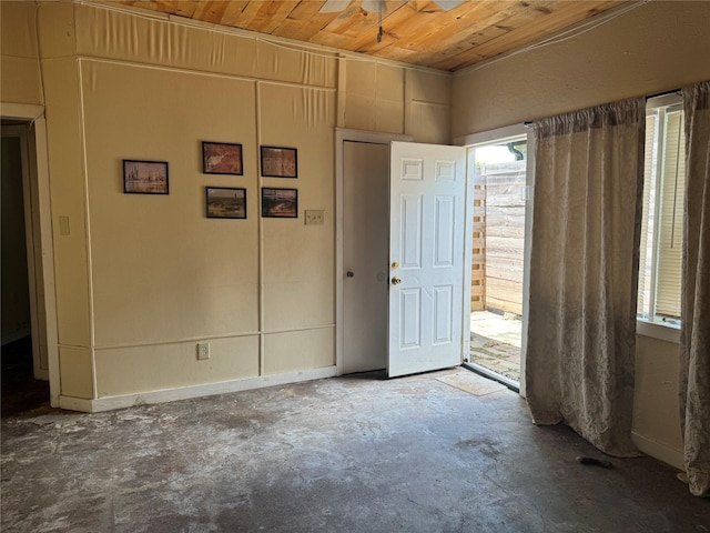 unfurnished room with concrete floors and wooden ceiling