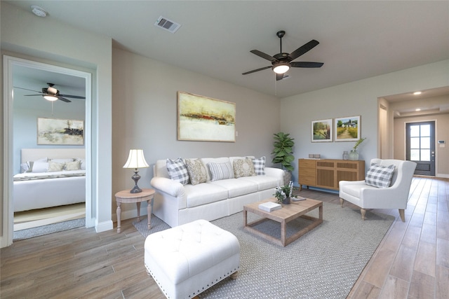 living room featuring ceiling fan and hardwood / wood-style floors