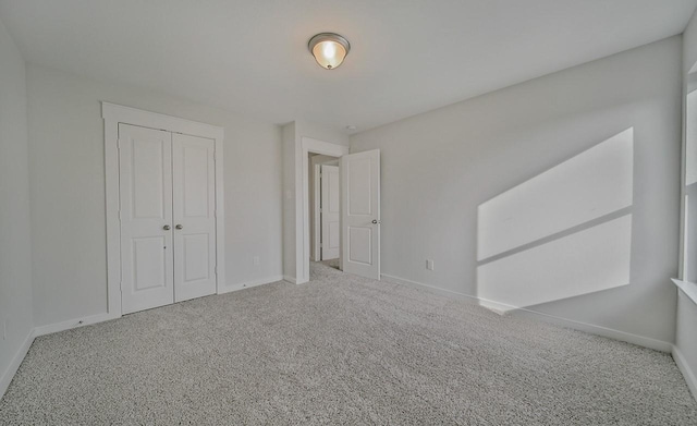 unfurnished bedroom with carpet floors, baseboards, and a closet