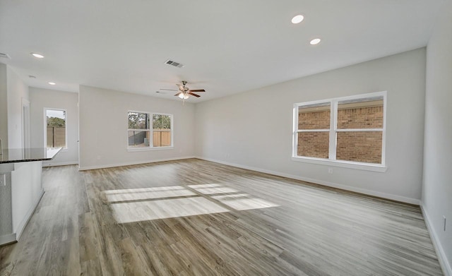 unfurnished living room featuring light hardwood / wood-style flooring and ceiling fan