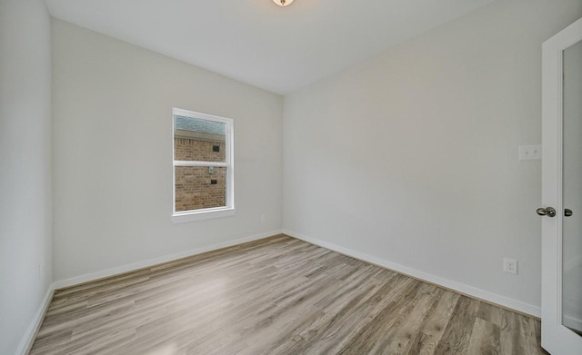 empty room featuring wood finished floors and baseboards