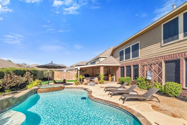 view of swimming pool featuring an in ground hot tub and a patio area