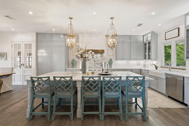 kitchen featuring dark wood-type flooring, sink, dishwasher, gray cabinets, and a large island