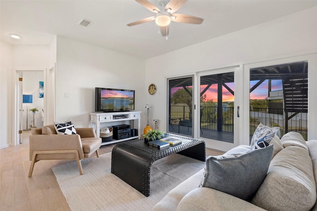 living room with ceiling fan and light wood-type flooring