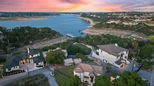 aerial view at dusk featuring a water view