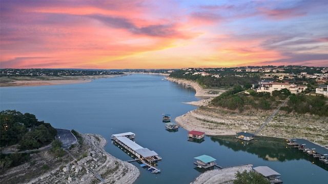 aerial view at dusk featuring a water view