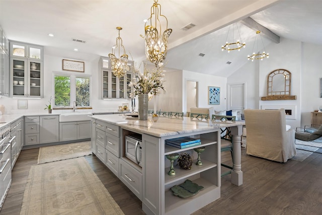 kitchen featuring decorative light fixtures, a kitchen island, dark hardwood / wood-style floors, and a breakfast bar area