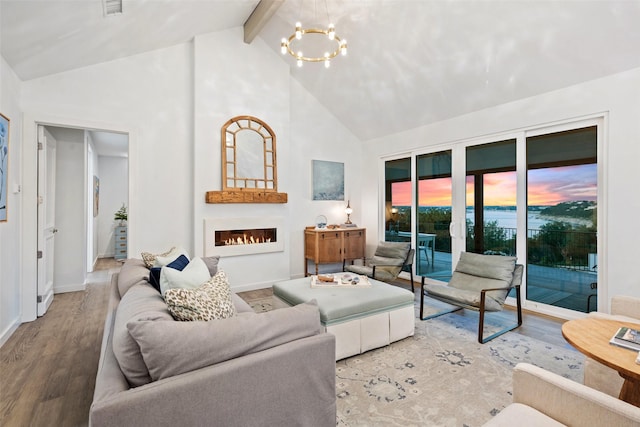 living room featuring beam ceiling, french doors, high vaulted ceiling, hardwood / wood-style floors, and a chandelier