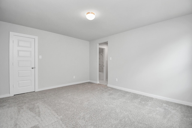 empty room featuring carpet floors and baseboards