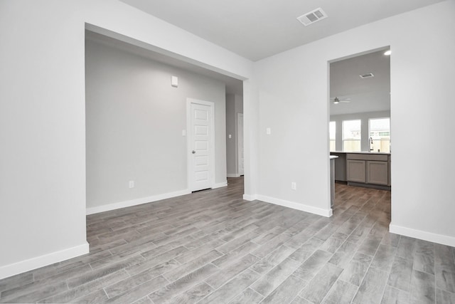 unfurnished room with baseboards, visible vents, and light wood finished floors