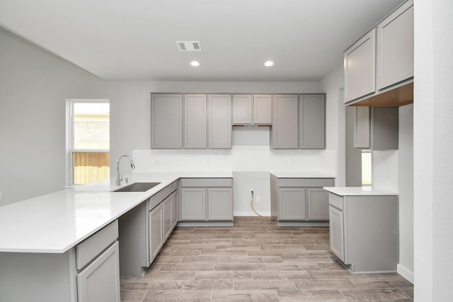 kitchen featuring gray cabinets, light hardwood / wood-style flooring, and sink