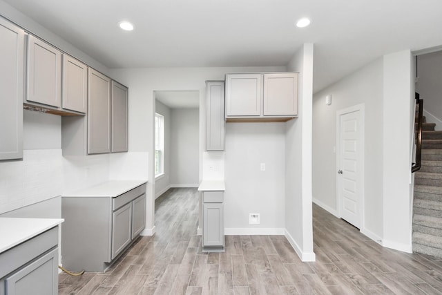 kitchen featuring light countertops, gray cabinetry, light wood finished floors, and recessed lighting