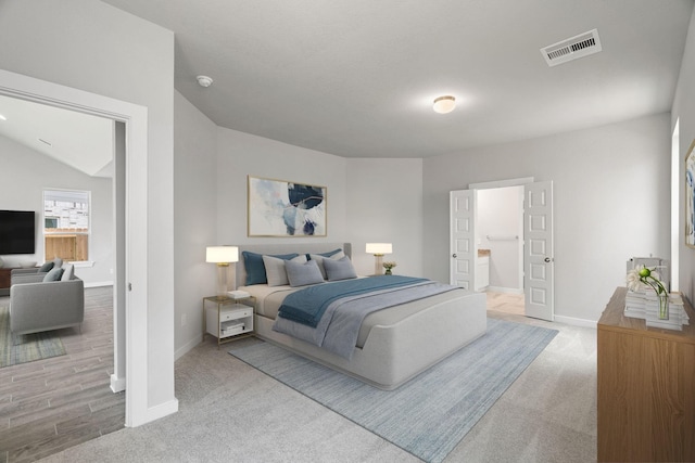 bedroom featuring light hardwood / wood-style floors and lofted ceiling