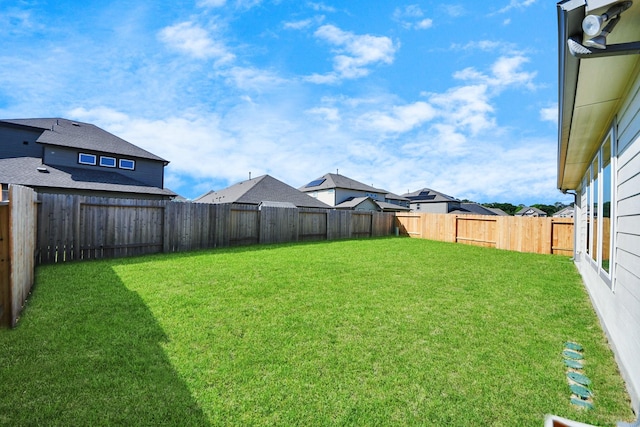 view of yard with a fenced backyard and a residential view