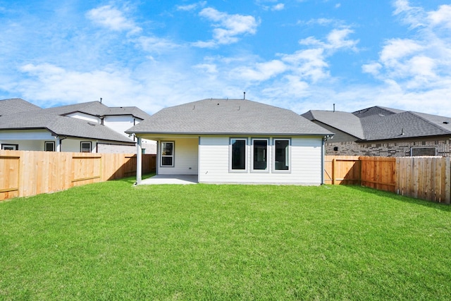 rear view of property with a fenced backyard, a yard, and a patio