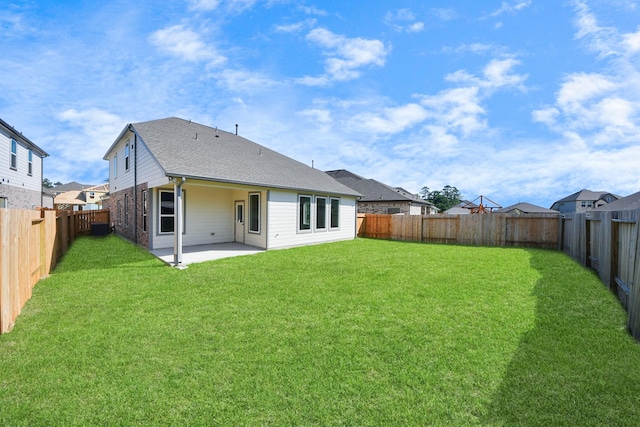 back of property featuring a patio area, a fenced backyard, roof with shingles, and a yard
