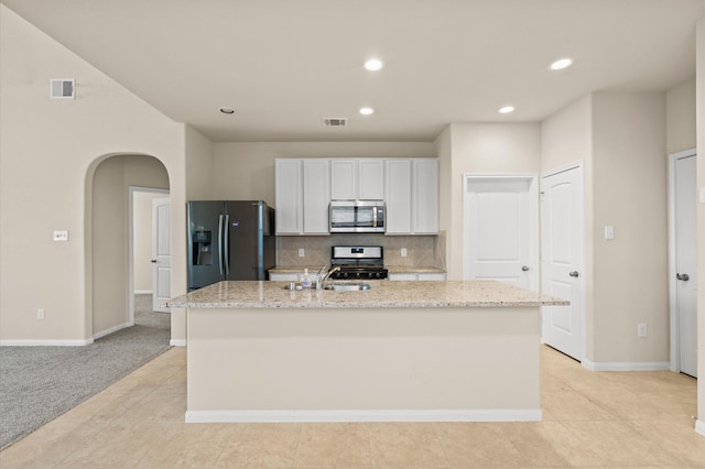 kitchen with white cabinetry, a kitchen island with sink, light colored carpet, and appliances with stainless steel finishes