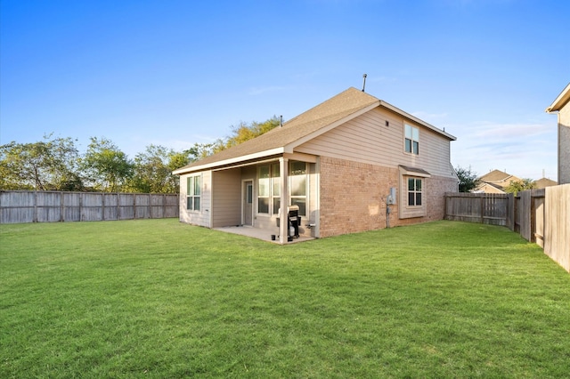 rear view of house with a lawn and a patio area