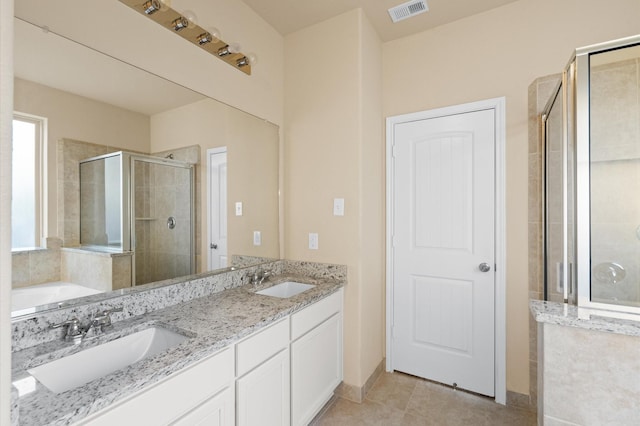 bathroom featuring tile patterned flooring, vanity, and shower with separate bathtub