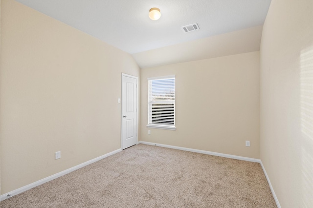 carpeted empty room featuring lofted ceiling