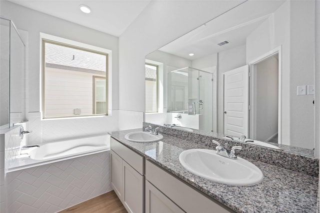 bathroom with wood-type flooring, vanity, and separate shower and tub