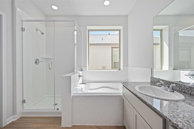 bathroom featuring hardwood / wood-style floors, vanity, and shower with separate bathtub