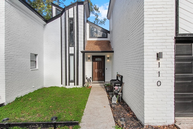 entrance to property with a lawn