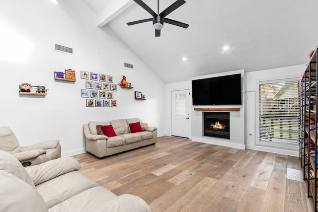 living room with beamed ceiling, ceiling fan, light wood-type flooring, and high vaulted ceiling