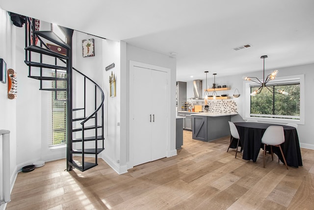 interior space featuring wood-type flooring, a wealth of natural light, and an inviting chandelier