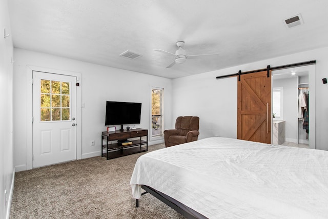 bedroom with a barn door, carpet floors, and ceiling fan